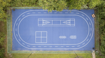 A basketball court with a road drawn on it on a field